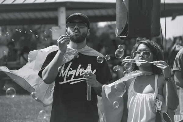 b&w photo of people blowing bubbles