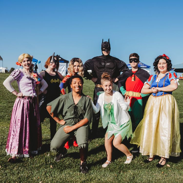 group of people dressed up as superheroes and princesses